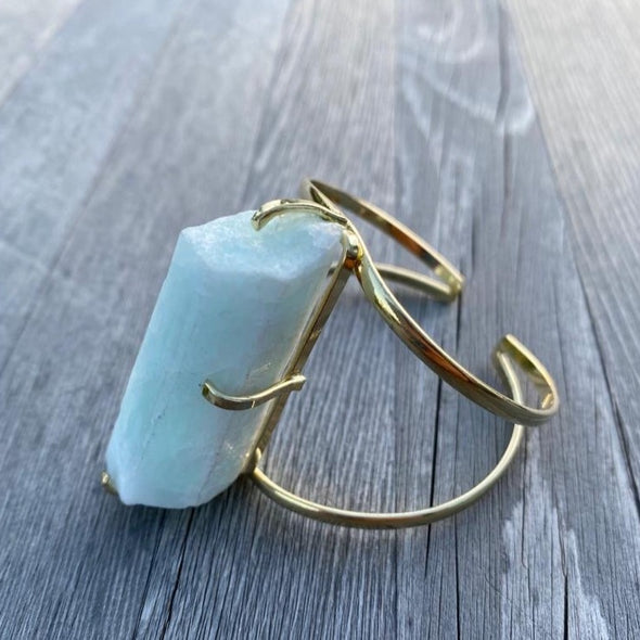 This raw Aquamarine bangle bracelet  an elegant gold plated bangle bracelet 5x2cm. Aquamarine is an incredibly relaxing stone that provides courage to overcome difficult times. 