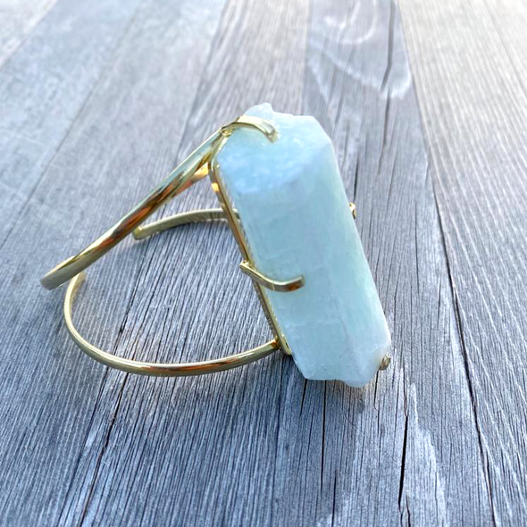 This raw Aquamarine bangle bracelet  an elegant gold plated bangle bracelet 5x2cm. Aquamarine is an incredibly relaxing stone that provides courage to overcome difficult times. 